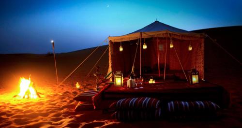a tent in the desert with a fire in the sand at Jaisalmer Night Safari Camp in Jaisalmer