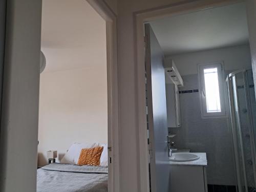 une chambre avec un lit, un lavabo et un miroir dans l'établissement Chambre indépendante, à Rou-Marson