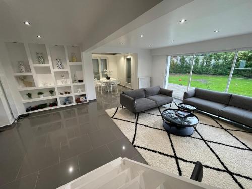 un salon avec deux canapés et une grande fenêtre dans l'établissement Maison dans résidence américaine, à Lésigny