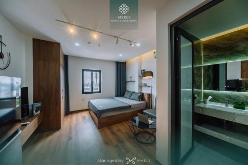 een slaapkamer met een bed en een badkamer met een wastafel bij Merci Hotel & Apartment - Le Hong Phong, Hai Phong in Hai Phong