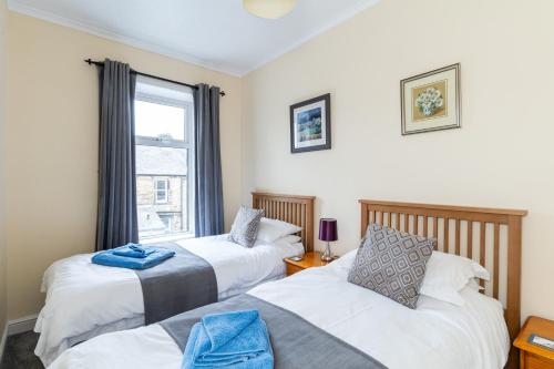 a bedroom with two beds and a window at BELLE VUE - SKIPTON in Skipton