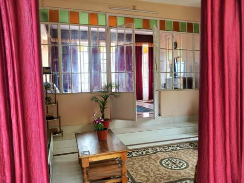 a room with red curtains and a table and a window at SAI´S GRACE in Kalimpong