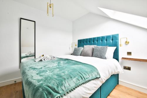 um quarto com uma cama grande e uma cabeceira azul em North Road Luxe New Serviced Apartments- Parking Available with Full Kitchen Amenities em Cardiff