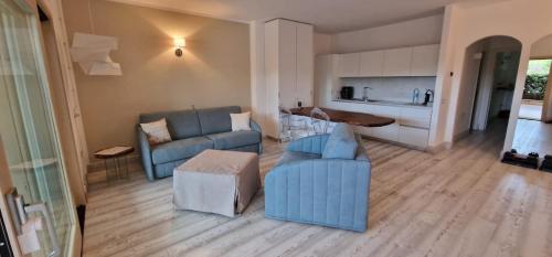a living room with blue furniture and a kitchen at LOTUS Wellness Apartment - Resort Ginestre - Palau - Sardinia in Palau