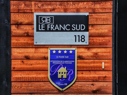 a sign on the side of a building with a house at Destination Franc Sud Gaspésie in Cascapedia