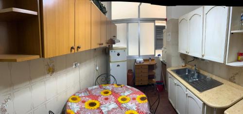 una cocina con fregadero y mesa. en Arco di ballarò, en Palermo
