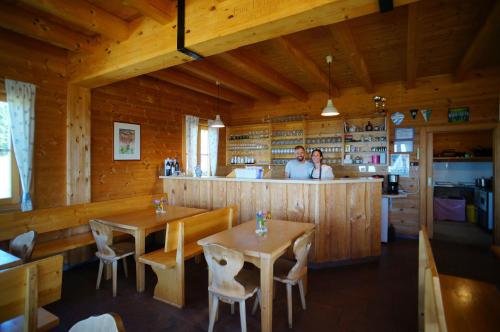zwei Personen in einem Restaurant mit Tischen und einer Bar in der Unterkunft Glatzl Trahütten Alm in Sankt Lorenzen am Wechsel