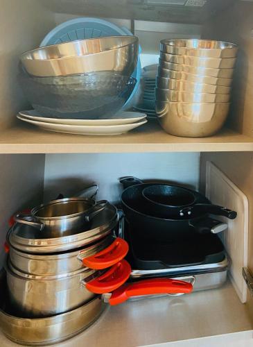 two shelves filled with pots and pans and red scissors at LOTUS Wellness Apartment - Resort Ginestre - Palau - Sardinia in Palau