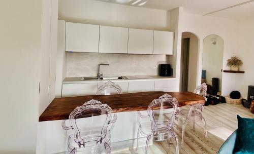 a kitchen with a counter with chairs and a sink at LOTUS Wellness Apartment - Resort Ginestre - Palau - Sardinia in Palau