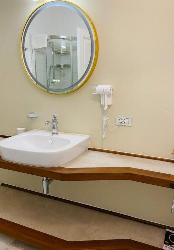 a bathroom with a sink and a mirror at LOTUS Wellness Apartment - Resort Ginestre - Palau - Sardinia in Palau