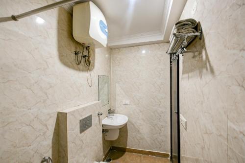 a bathroom with a shower and a toilet and a sink at Airport Hotel Ark View in New Delhi