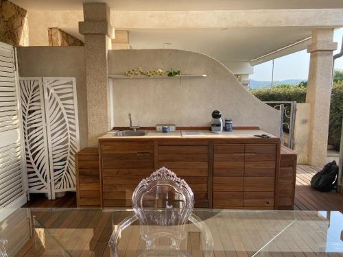 uma cozinha com um lavatório e uma cadeira num pátio em LOTUS Wellness Apartment - Resort Ginestre - Palau - Sardinia em Palau