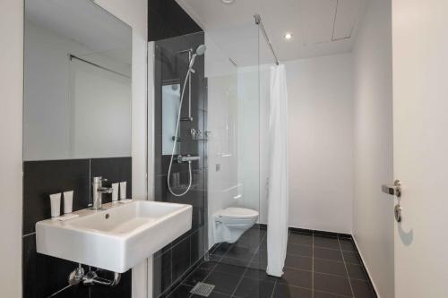a bathroom with a sink and a shower and a toilet at Stylish Apartments in CPH City in Copenhagen