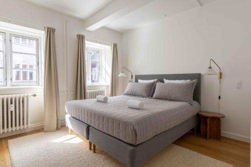a bedroom with a large bed and two windows at Stylish Apartments in CPH City in Copenhagen