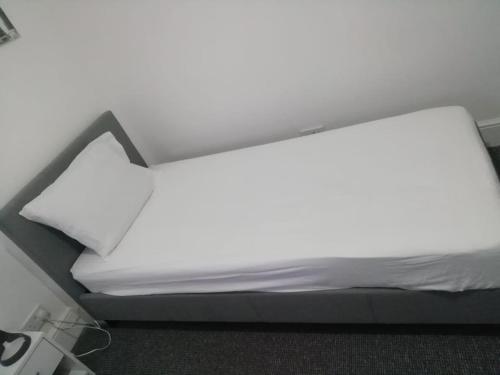 a bed with white sheets and a white pillow at Single Room Shared bathroom Free Street Parking Near Anfield LFC in Liverpool