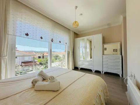 Evalacati - Villa Harnup- Newly Renovated Villa في ألاتشاتي: غرفة نوم بسرير كبير مع نافذة كبيرة