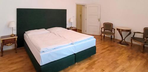 a bedroom with a bed and two chairs and a table at Residence Romanza in Mariánské Lázně
