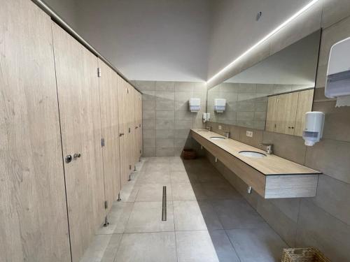 łazienka z 2 umywalkami i dużym lustrem w obiekcie ARDENNE CAMPING MABOGE w La-Roche-en-Ardenne