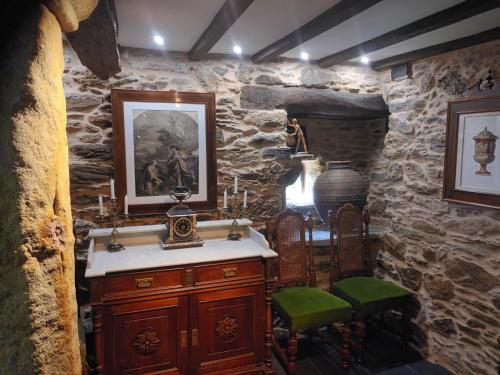 a bathroom with a sink and a stone wall at Mercadoiro in Laje