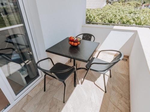 a small black table and chairs on a balcony at Apartments Milivojevic in Bar