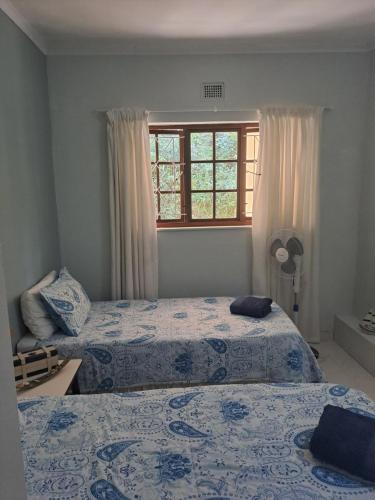 a bedroom with two beds and a window at Eden Wilds 6 Paradise on Umtavuna River in Port Edward