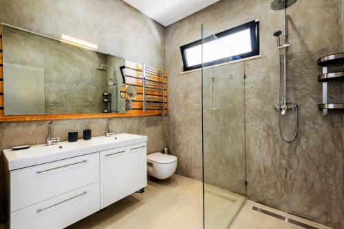a bathroom with a toilet and a glass shower at Casa da Calma in Vale do Lobo