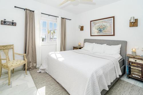 1 dormitorio blanco con 1 cama y 1 silla en AB2 - Aldea Blanca Marbella by Roomservices en Marbella