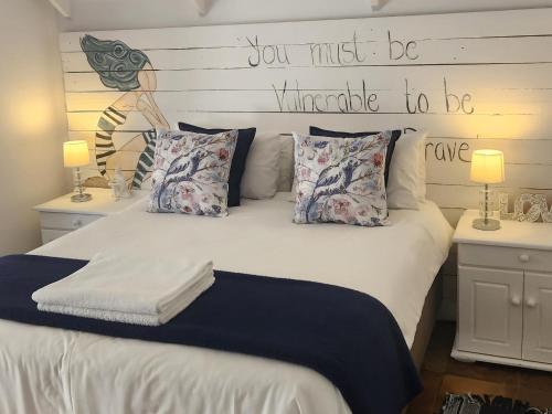 1 dormitorio con 1 cama con un cartel en el cabecero en Be Our Guest Self Catering, en Nelspruit