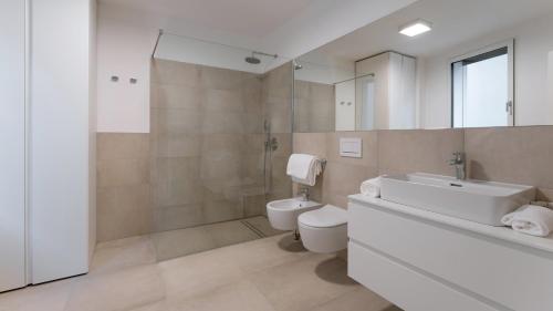a bathroom with a sink and a toilet and a mirror at Serviced Apartments by Hotel de Charme Laveno in Laveno