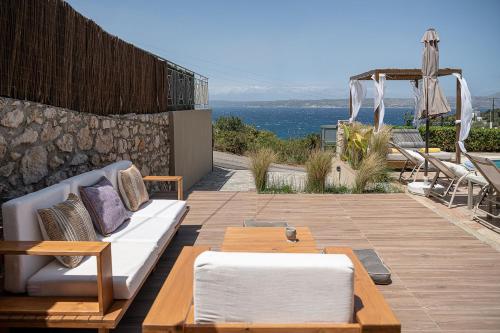 a patio with a white couch and a table at Villa Nicolas Plaka With Sea View in Plaka