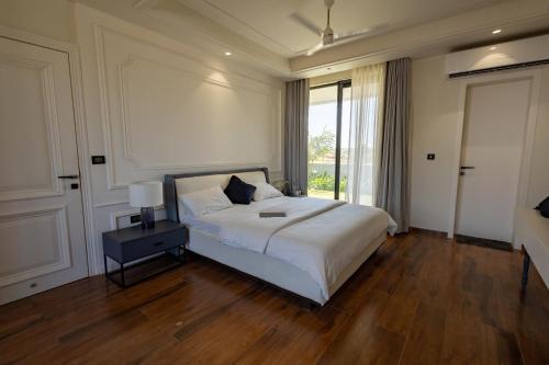 a bedroom with a bed and a large window at Cahaya - Beachouse 4BHK Villa with Jacuzzi & Home Theatre, 7 minute walk to the beach in Mandvi