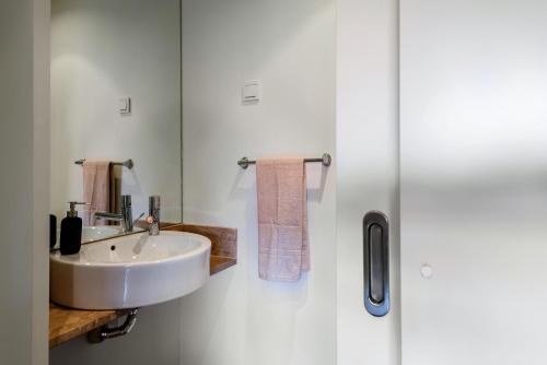 uma casa de banho branca com um lavatório e um espelho em L'Orangerie em Vilamoura