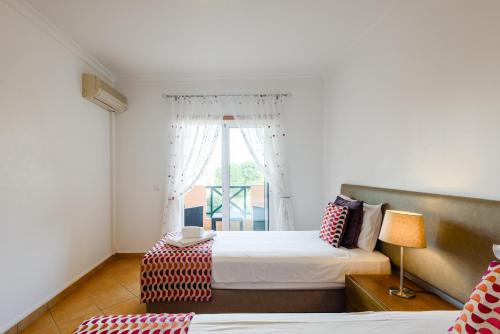 a bedroom with two beds and a window at Quinta do Paiva - Jardins do Vale in Albufeira