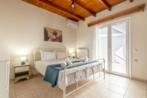 1 dormitorio con cama y ventana grande en Lovely Maisonette in the village, en Márathos