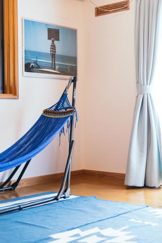 a hammock in a room with a picture on the wall at ocean villa mint 満天の星空とオーシャンビューで心満たす一棟まるごと貸切別荘 南房総千倉 in Chikura