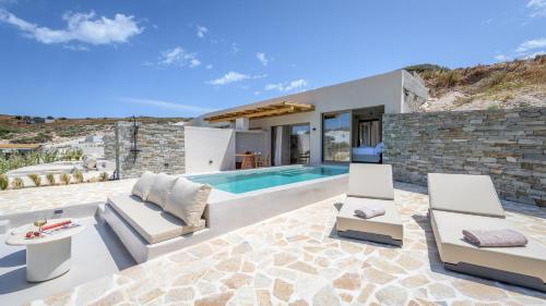 a villa with a swimming pool and a house at Solus Suites Milos in Adamas
