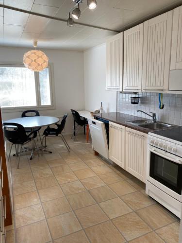 uma cozinha com uma mesa e uma mesa e cadeiras em Big Duplex, 15min to Turku or Naantali em Turku