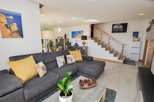 uma sala de estar com um sofá cinzento e uma mesa em Garden Hill Relax & Old Town by OCvillas em Albufeira