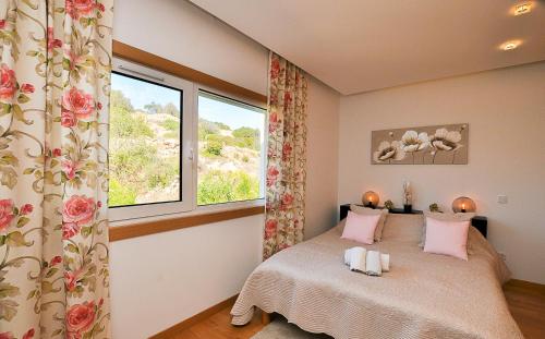 um quarto com uma cama com almofadas cor-de-rosa e uma janela em Garden Hill Relax & Old Town by OCvillas em Albufeira