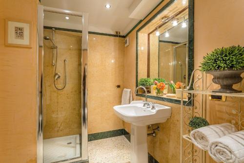 y baño con lavabo y ducha. en Casa Eleonora charming quiet apartment, en Lucca