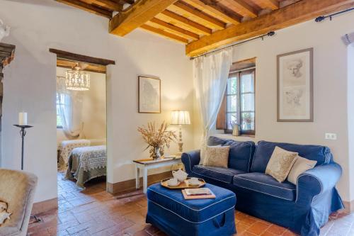 uma sala de estar com um sofá azul e uma mesa em Casa Cassettari, Apartment with Garden and pool em Ghivizzano
