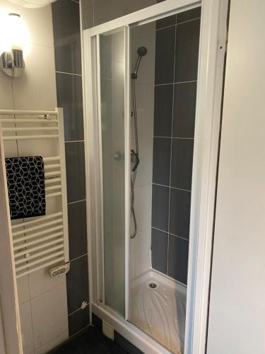 une douche avec une porte vitrée dans une salle de bain dans l'établissement Cosy appartement 2P, 10 mn Paris Opéra, à Aubervilliers