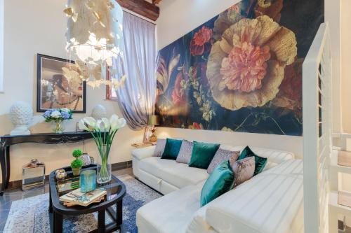 a living room with a white couch and a painting at CASA EDA, Modern Contemporary Central Apartment inside the Walls of Lucca in Lucca