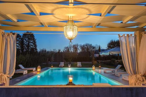 uma piscina com tecto e candelabro em Villa Otto Luxury Tuscan Farmhouse with Pool em Orentano