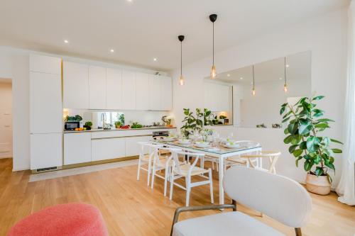 cocina blanca con mesa y sillas en Casa Daria, Modern 4 Bedrooms Apartment in Lucca, en Lucca