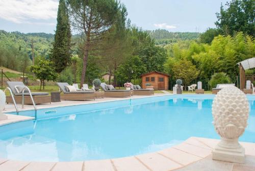 a large swimming pool with a resort style house at Le Bicocche Farmhouse: Country Stone Villa with Pool in Camaiore between Lucca & Beaches of Versilia in Montemagno