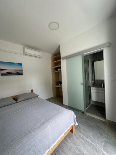 um quarto com uma cama e uma casa de banho com um lavatório em Room Sleep & Fly em Kaštela