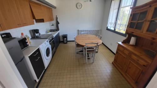 une cuisine avec une table et une table ainsi qu'un lave-linge dans l'établissement Bel Appartement, à Vinassan
