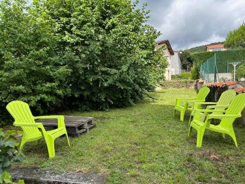 un grupo de sillas verdes sentadas en el césped en Au TRÈFLE DORT, en Châtel-Guyon