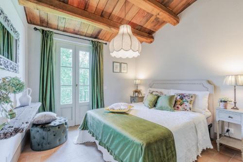 1 dormitorio con cama blanca y techo de madera en La Vaseria Country House with Secret Garden and pool, en Ghivizzano